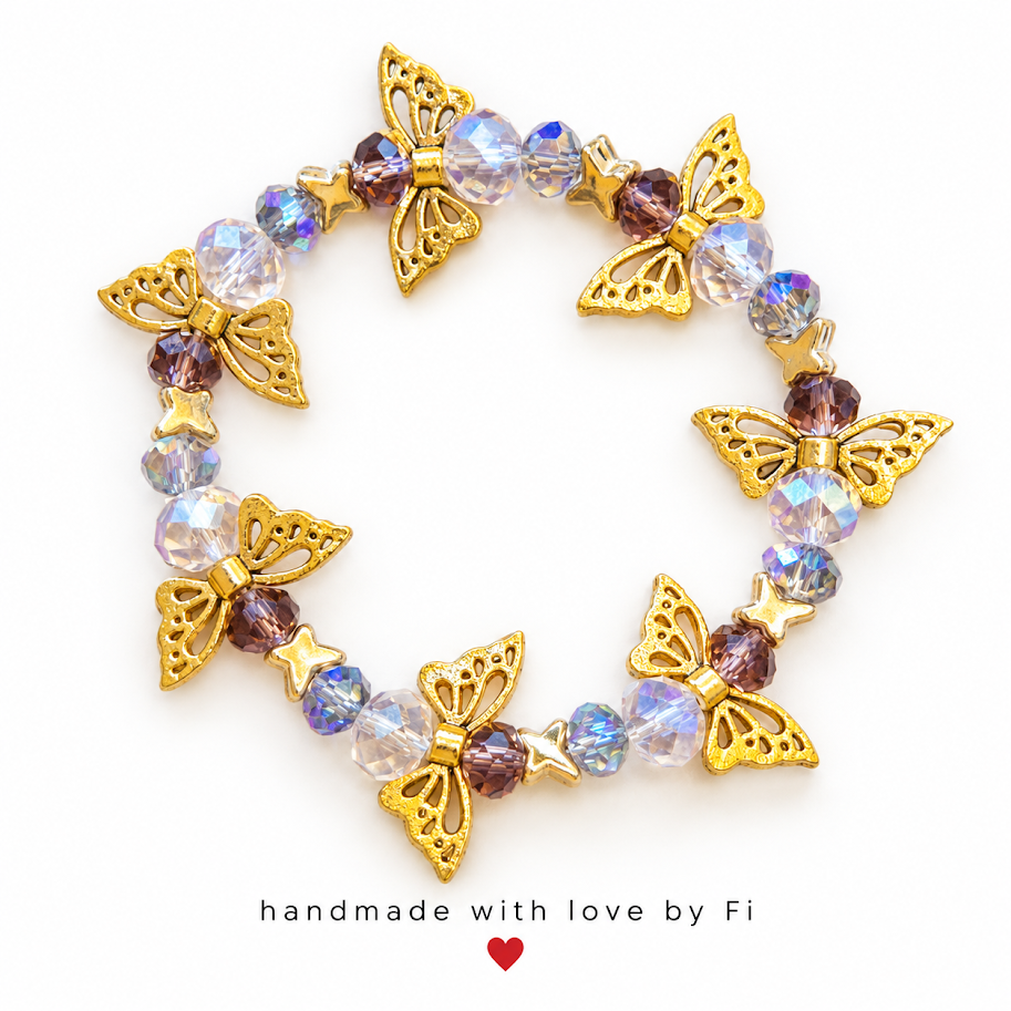 Gold-tone butterfly and star bracelet with clear iridescent and smoky purple faceted beads