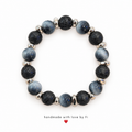 Handmade bracelet with textured black lava-style beads, smoky silver-grey beads and silver-tone spacers