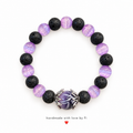 Handmade bracelet with black lava-style beads, lavender beads and a purple dragon-claw statement centre