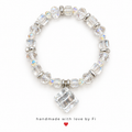 Clear faceted stretch bracelet with iridescent accents, silver-tone spacers and a large clear cube pendant