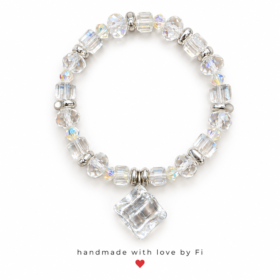 Clear faceted stretch bracelet with iridescent accents, silver-tone spacers and a large clear cube pendant