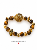 Golden-brown beaded bracelet with chip accents, gold-tone spacers and a large oval gold-coloured glitter centrepiece