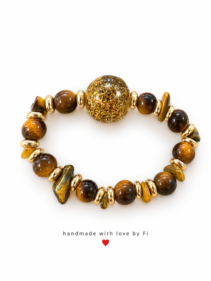 Golden-brown beaded bracelet with chip accents, gold-tone spacers and a large oval gold-coloured glitter centrepiece