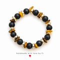 Textured black beaded bracelet with amber-coloured disc accents and gold-tone spacers