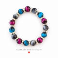 Glossy magenta and blue beads with textured charcoal-grey beads and silver-tone spacers