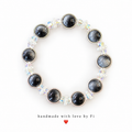 Charcoal-grey domed beads with silver-tone rims and clusters of clear iridescent beads
