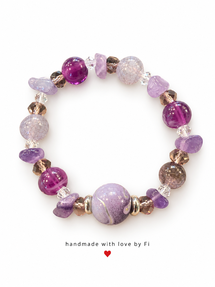 Purple and lilac beaded bracelet with chip accents, clear faceted beads and a large patterned lilac centrepiece