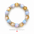 Pastel blue and golden beaded bracelet with decorative silver-tone spacers