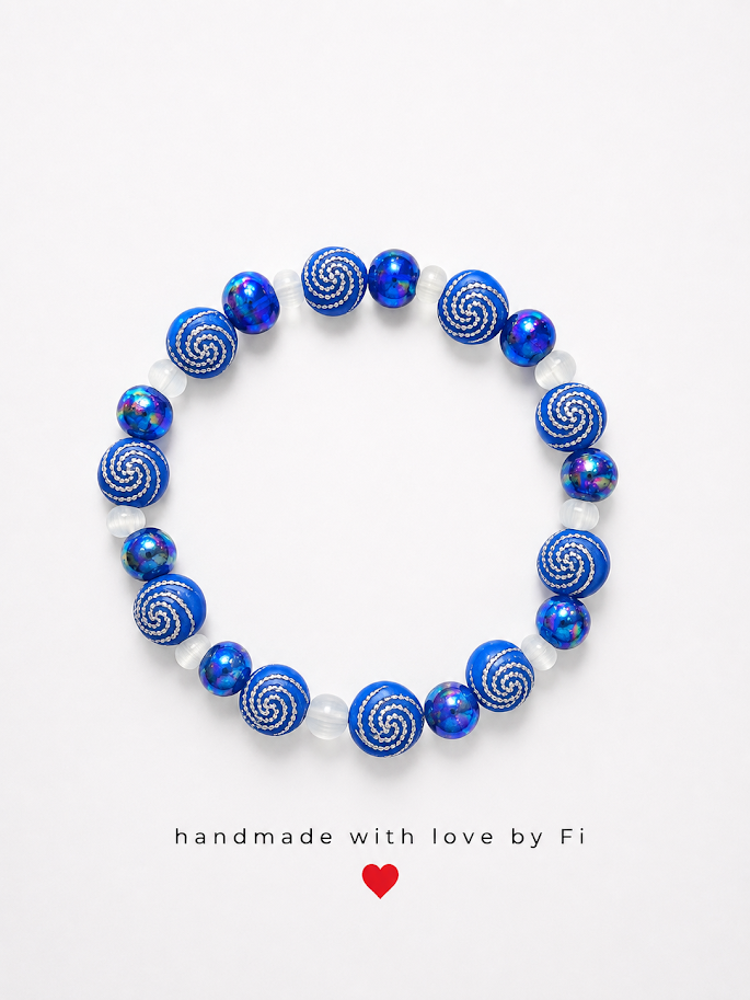 Cobalt blue iridescent and blue swirl patterned bead bracelet with frosted white spacers handmade by Fi